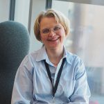 Kuvassa hymyilee Pirten ravitsemusterapeutti Katja, jolla on lyhyet vaaleat hiukset ja vaaleansininen paitapusero.