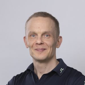 Kuvassa hymyilee Pirten fysioterapeutti Ilkka, jolla on vaaleahkot hiukset ja yllään tumma paita.