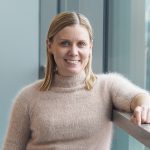 Kuvassa on Pirten lääkäri Susanne, jolla on vaaleat olkapäille ulottuvat hiukset ja yllään vaalea lyhythihainen neule.