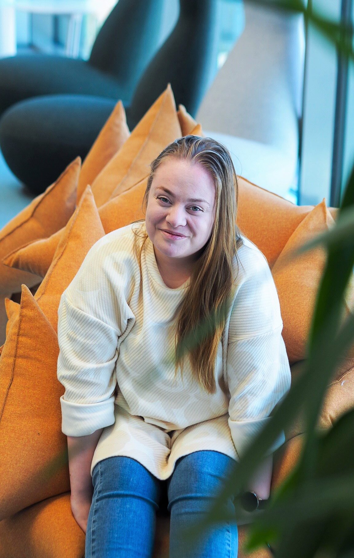 Kuvassa Pirten työterveyshoitaja Marianna Änäkäinen istuu oranssissa nojatuolissa hymyillen.