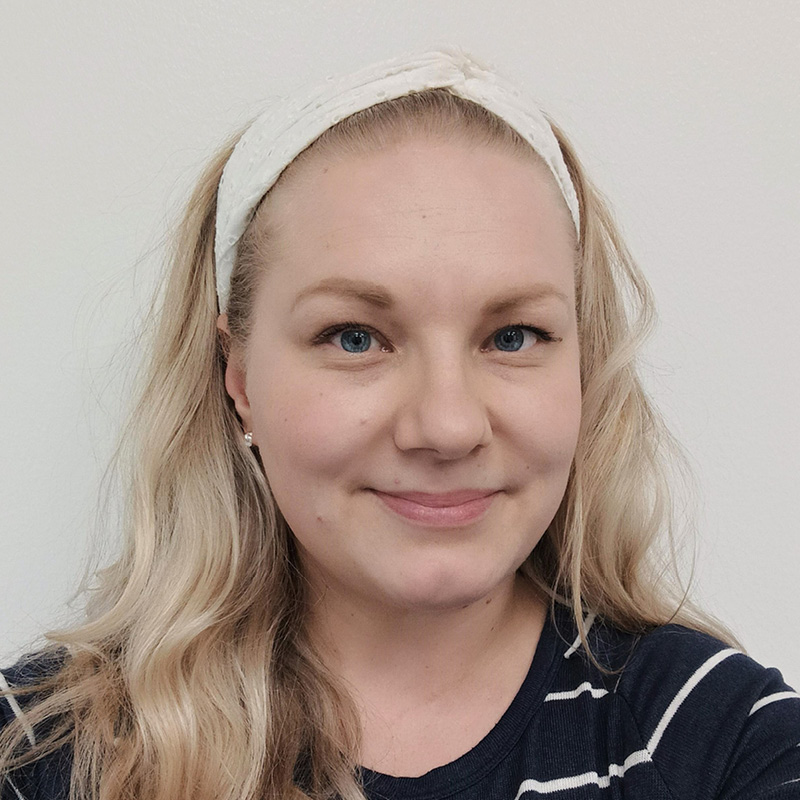 Kuvassa on Pirten työterveyshoitaja Anna-Mari, jolla on pitkät vaaleat hiukset ja yllään tumma raitapusero.